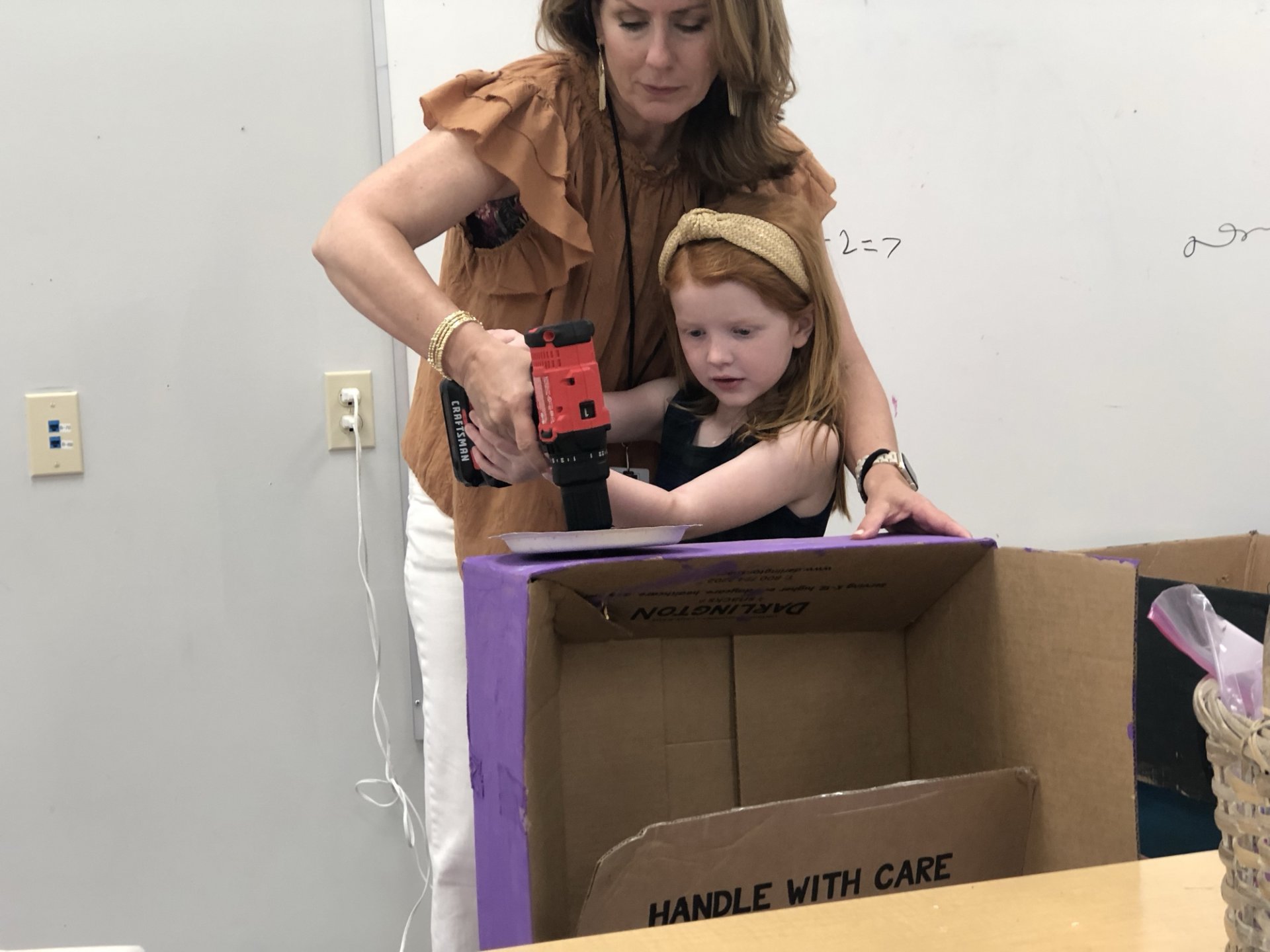Kindergarten student with cardboard car