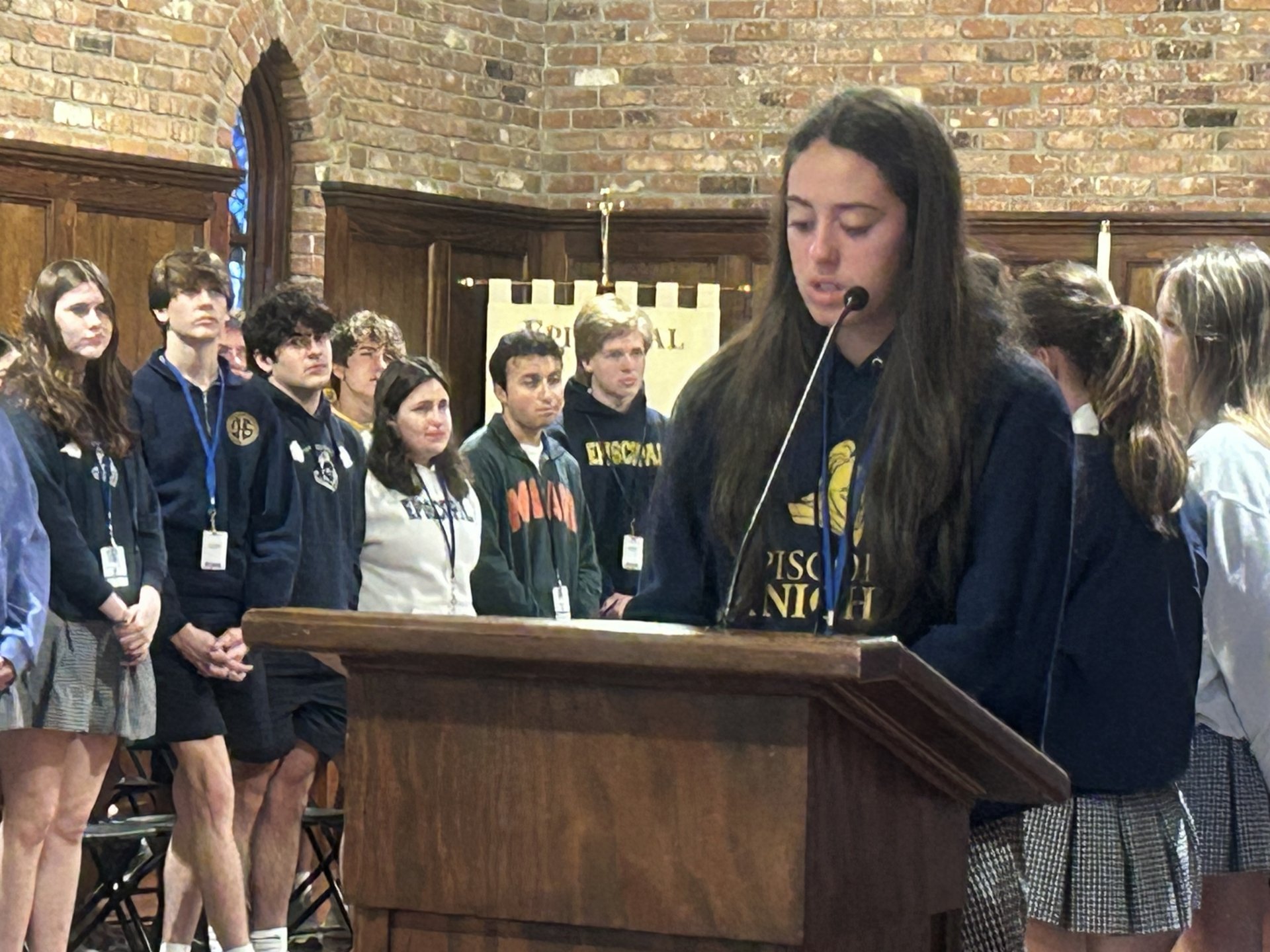 Student leading prayers in chapel